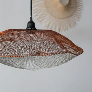 Handcrafted wire mesh pendant light with organic shape and minimalist decor background
