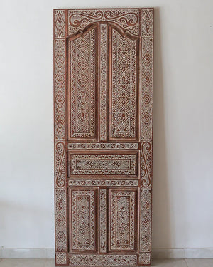 Hand-carved Balinese wooden door with intricate geometric and floral patterns