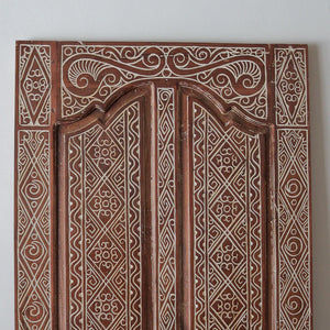 Hand-carved Balinese wooden door panel with intricate geometric patterns