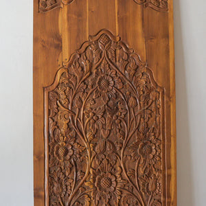 Hand-carved wooden door panel with intricate floral Balinese design detail
