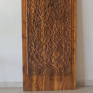 Hand-carved wooden Balinese door with intricate floral patterns, eco-friendly home decor