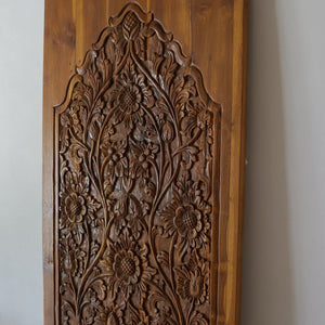 Hand-carved wooden door panel with intricate floral Balinese design