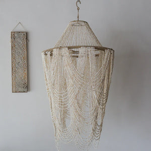 Handmade Balinese seashell chandelier with draped beads, boho wall art on white background
