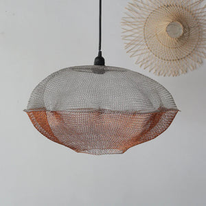 Handcrafted metal mesh pendant light in organic shape with minimalist decor background
