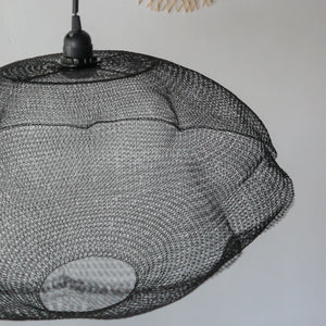 Handmade black wire mesh pendant light with modern, textured design against white wall