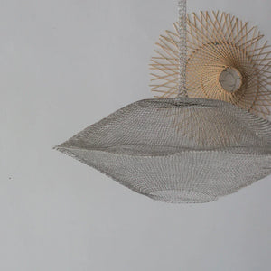 Handmade woven pendant light with intricate metallic mesh and natural rattan wall decor