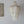 Handmade Balinese seashell chandelier with cascading white capiz shells beside a carved wall art.