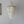 Handmade seashell chandelier with cascading white shell strands against a plain wall.