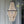 Handmade wooden bead chandelier with black metal frame, hanging outdoors by glass doors
