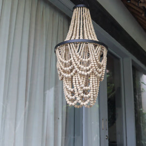 Handmade Balinese beaded chandelier with natural wood beads hanging outdoors