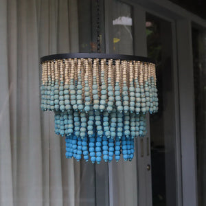Handmade beaded chandelier with gradient blue and natural wooden beads, outdoor setting