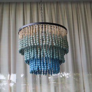 Blue and natural wooden bead chandelier with tiered coastal design hanging indoors