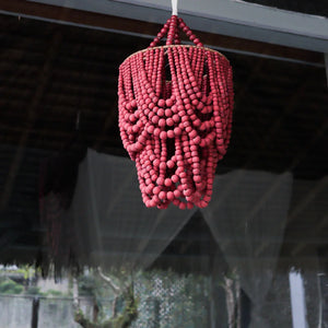 Handmade red beaded chandelier hanging indoors, Boho decor accent, eco-friendly lighting