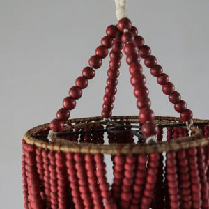 Handmade red beaded chandelier with boho decor style, close-up detail.
