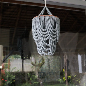 Handmade beaded chandelier with grey beads hanging outdoors, showcasing Balinese decor style