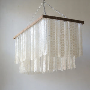 Handmade rectangle Capiz shell chandelier with a wooden frame and hanging chain, unique design from Bali.