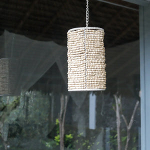 Handmade Balinese beaded chandelier hanging by a chain in a modern outdoor space
