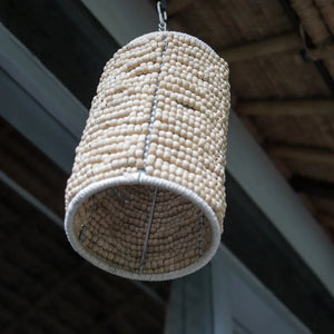 Handmade cylindrical beaded chandelier with natural wooden beads hanging indoors