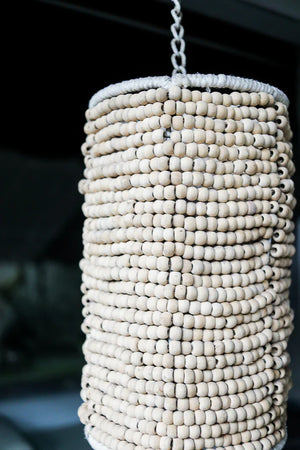 Handmade Balinese beaded pendant light with natural wood beads, hanging on a chain