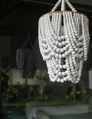 Handmade white bead chandelier in natural outdoor setting, Balinese decor accent
