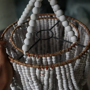 Handmade white wooden bead chandelier with rustic twine accents, close-up view