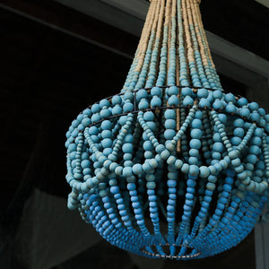 Handmade blue beaded chandelier with natural wood accents, artisanal Balinese home decor
