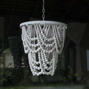 Handmade white beaded chandelier with cascading design, hanging in natural light.