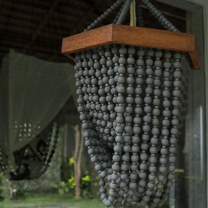Handmade Balinese beaded chandelier with dark wooden frame, boho home decor accent.