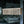 Rectangular natural wood bead chandelier with jute accents, hanging indoors by window