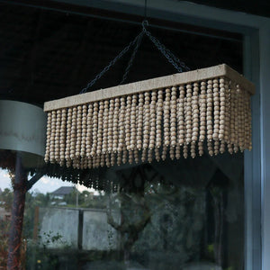 Handcrafted rectangular wood bead chandelier with natural finish, hanging near a window