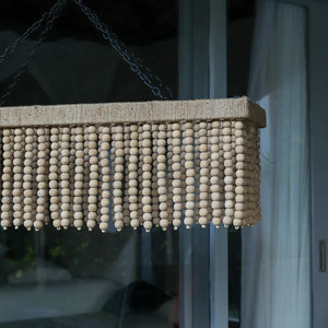 Handmade rectangular beaded chandelier with natural wood beads, hanging indoors