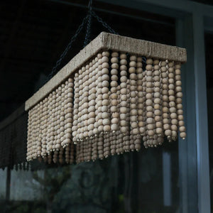 Handmade wooden bead chandelier with rectangular frame, hanging in natural light.