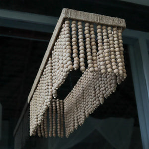 Handmade wooden bead chandelier with rectangular frame, hanging in a modern interior space.