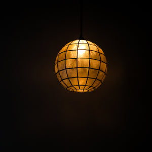Globe-shaped seashell chandelier with grid pattern, emitting warm ambient light for luxury home decor