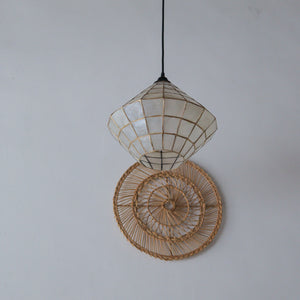 Handcrafted seashell pendant light with geometric design, paired with woven rattan wall art for boho home decor