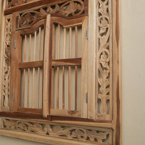 Hand-carved Balinese wooden window with intricate floral patterns and natural wood finish