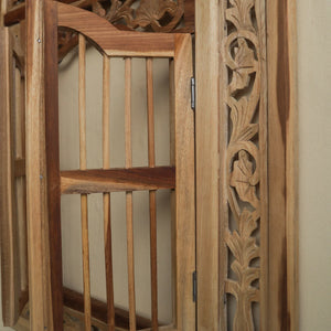 Hand-carved Balinese wooden door with intricate floral detailing and natural finish