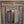 Hand-carved Balinese teak wood window with intricate floral patterns and blue accents