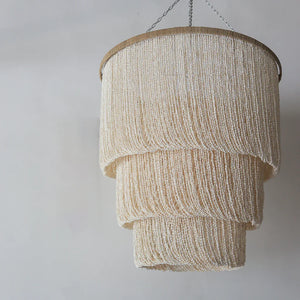 Handmade seashell chandelier with layered design and natural woven textures, hanging indoors