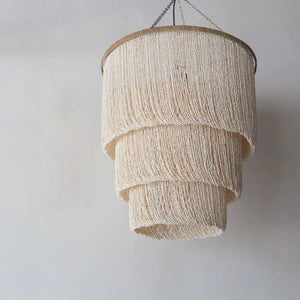 Handmade seashell chandelier with layered, natural beads hanging from a chain
