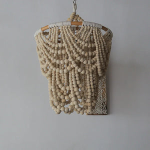 Boho hanging chandelier with natural wooden beads and carved wall bracket, neutral decor
