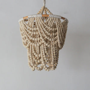 Handcrafted wooden beaded chandelier with natural finish, hanging against a white wall