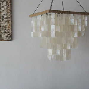Square tiered seashell chandelier with natural capiz shells, hanging in a modern room