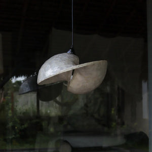 Handmade Balinese shell pendant light with organic, sculptural design hanging indoors