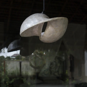 Handcrafted shell-shaped pendant light in natural setting, Balinese home decor
