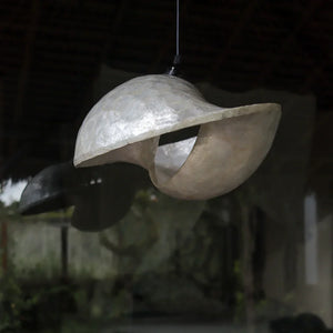 Handmade Balinese seashell pendant chandelier with organic, sculptural design hanging indoors.
