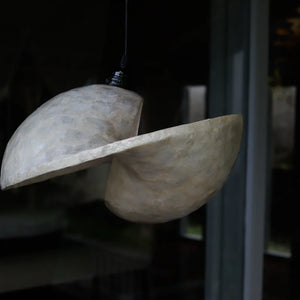 Handcrafted Balinese seashell pendant light with modern sculptural design, hanging indoors