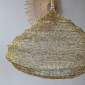 Handcrafted gold wire mesh pendant light with intricate woven pattern, modern home decor