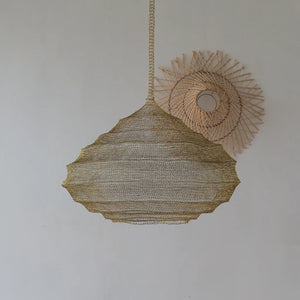 Handcrafted rattan pendant light with woven wall decor on a neutral background