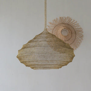 Handwoven natural fiber pendant light with a unique scalloped shape, minimal decor background